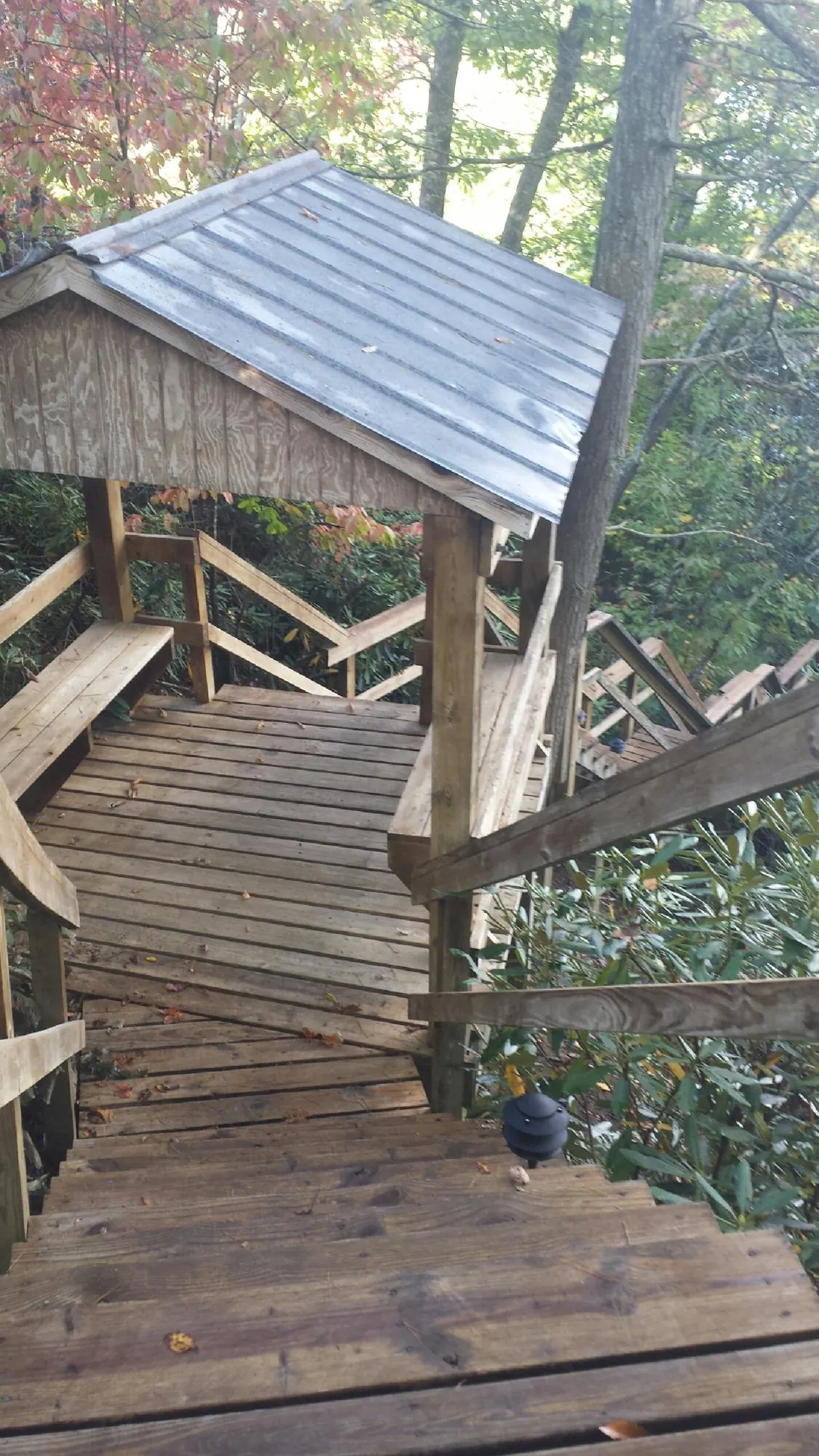 Metal roofed shelter over wooden steps on a wooded walkway in Wyandanch