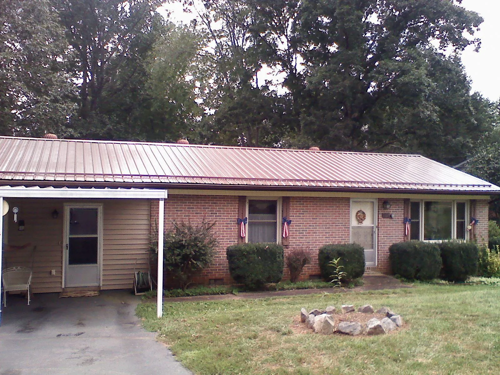 Bronze metal roof and carport on a brick ranch home — Roof Repair work by our crew in Wyandanch