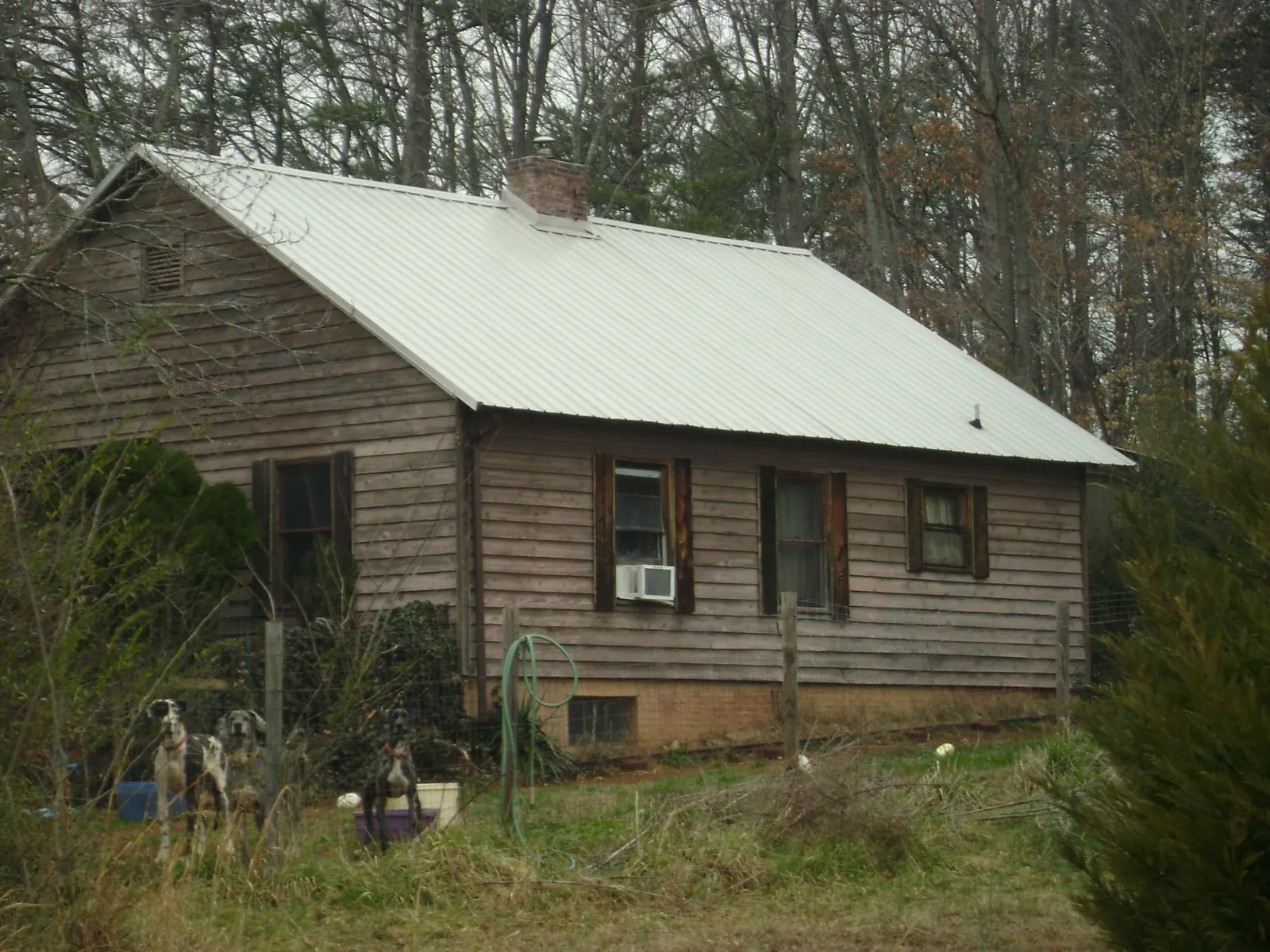 White metal roof on an old wood sided farmhouse, from a Metal Roof Installation job in Wyandanch